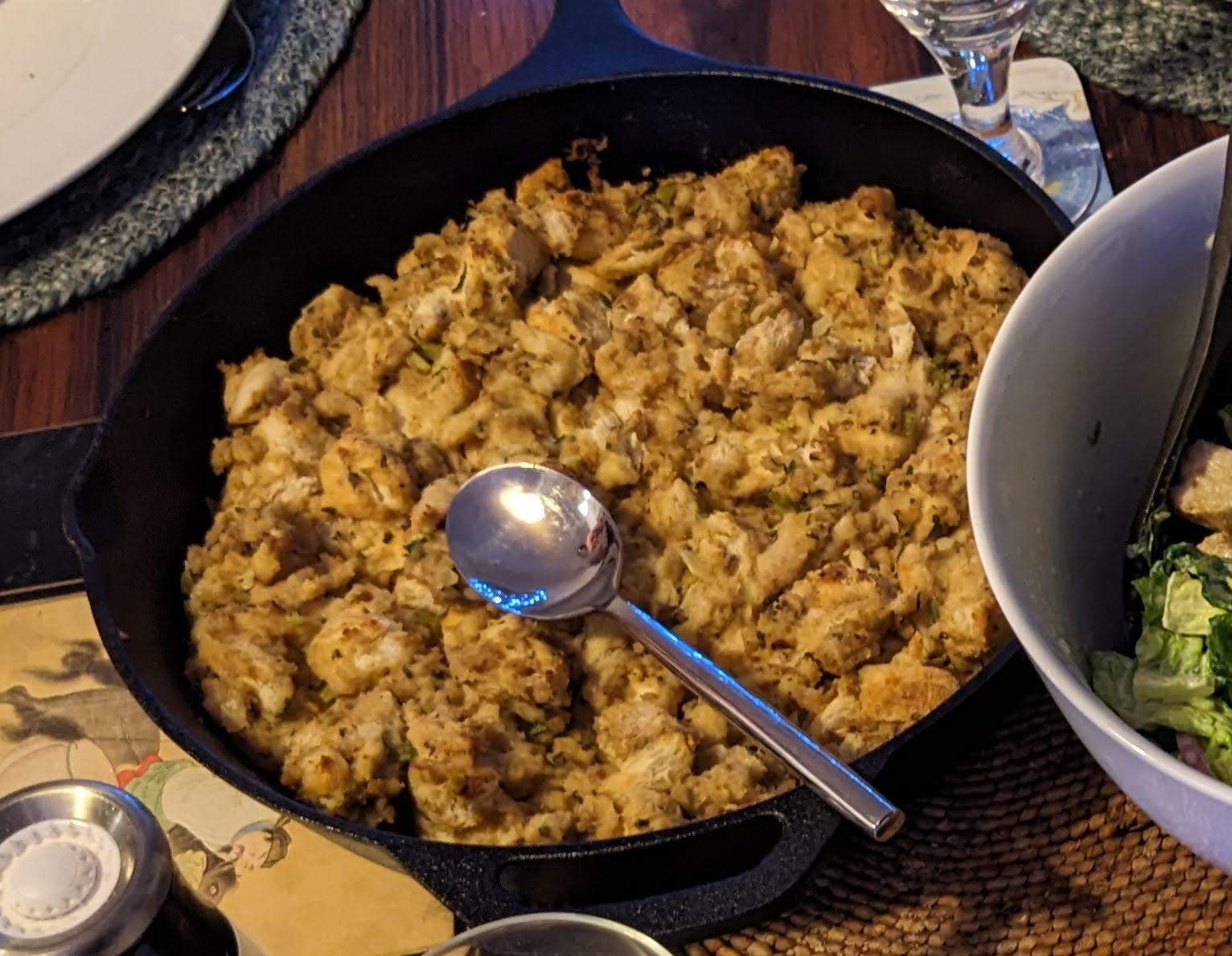 Golden brown bread and sausage stuffing in a cast iron pan. 